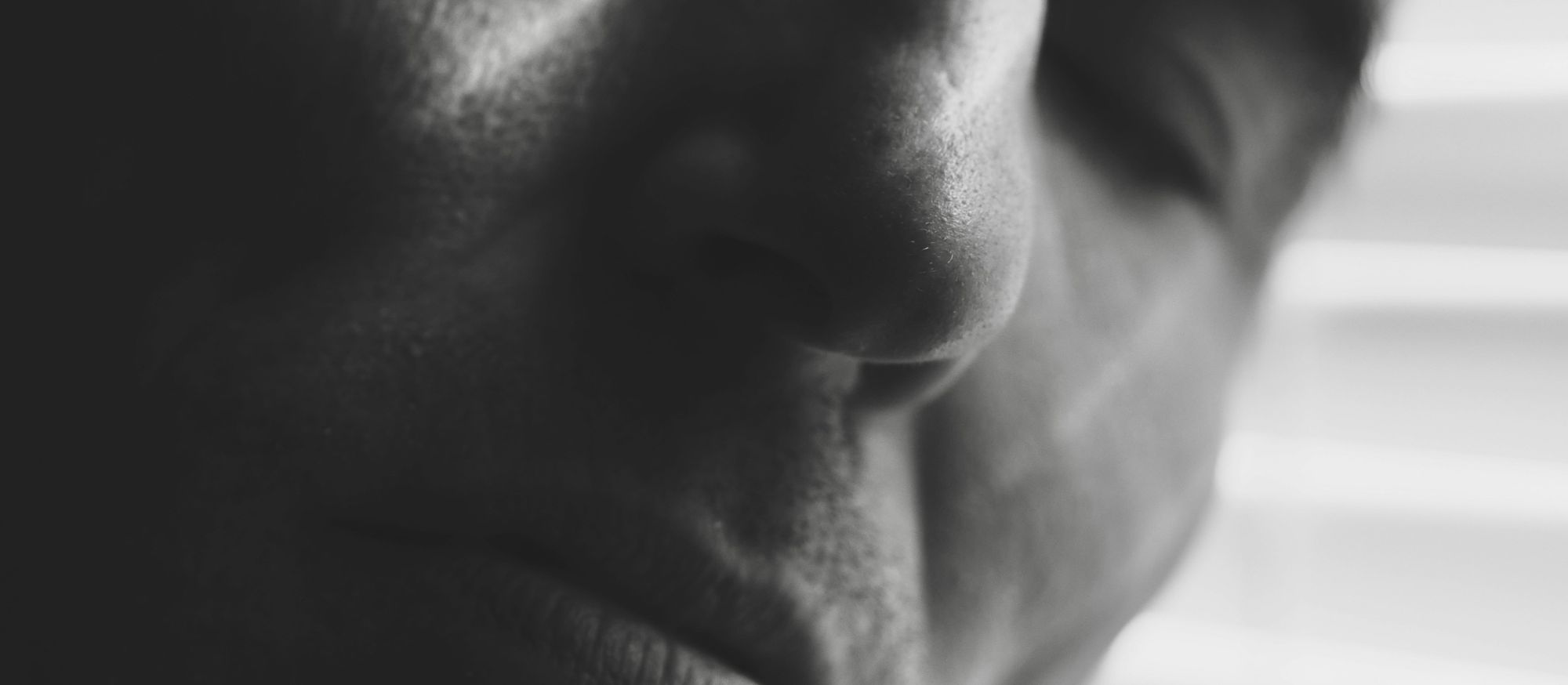 A close-up of a sleeping person's face, photographed in black and white.